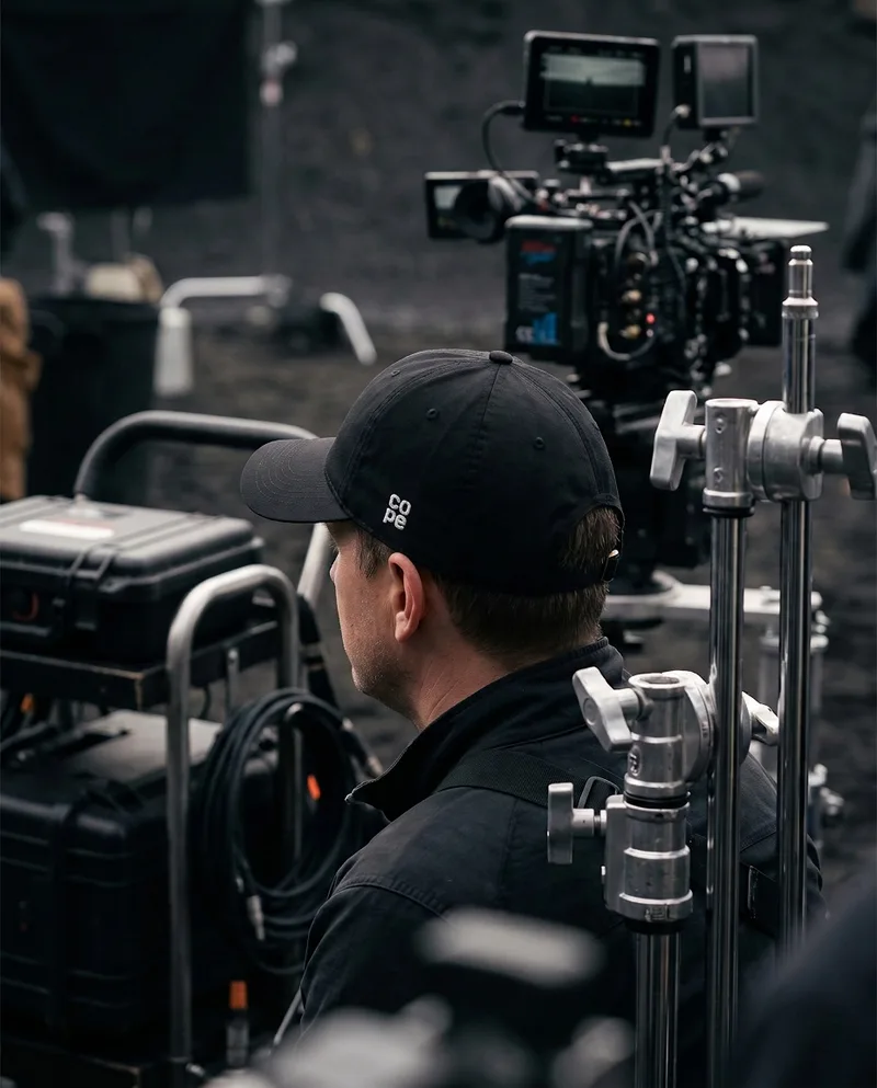 Crew member on a film set wearing the cope cap with the small side logo